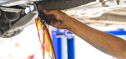 Oil draining from car into a bucket