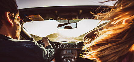 2 people driving towards sunshine