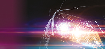 Close-up of a car with its lights on and a purple hue