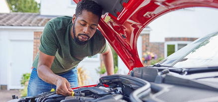 A person fixing his car with the car bonnet up