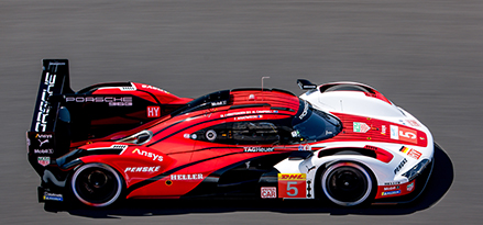 Red and white Porsche racing car on a track 