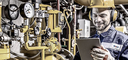 Mobil employee looking at an iPad next to a heat pump