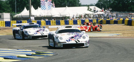 two Porsche race cars track image