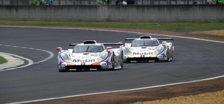 two Porsche race cars on track image